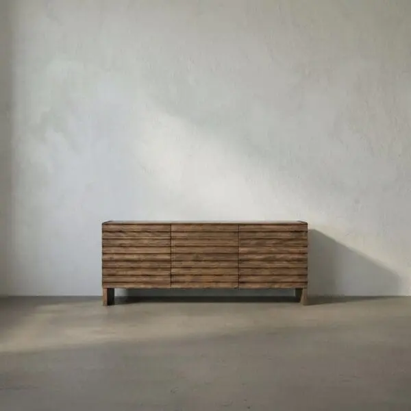 Low wooden sideboard with six drawers and a striped wood grain, raised on short legs, against a pale textured wall.